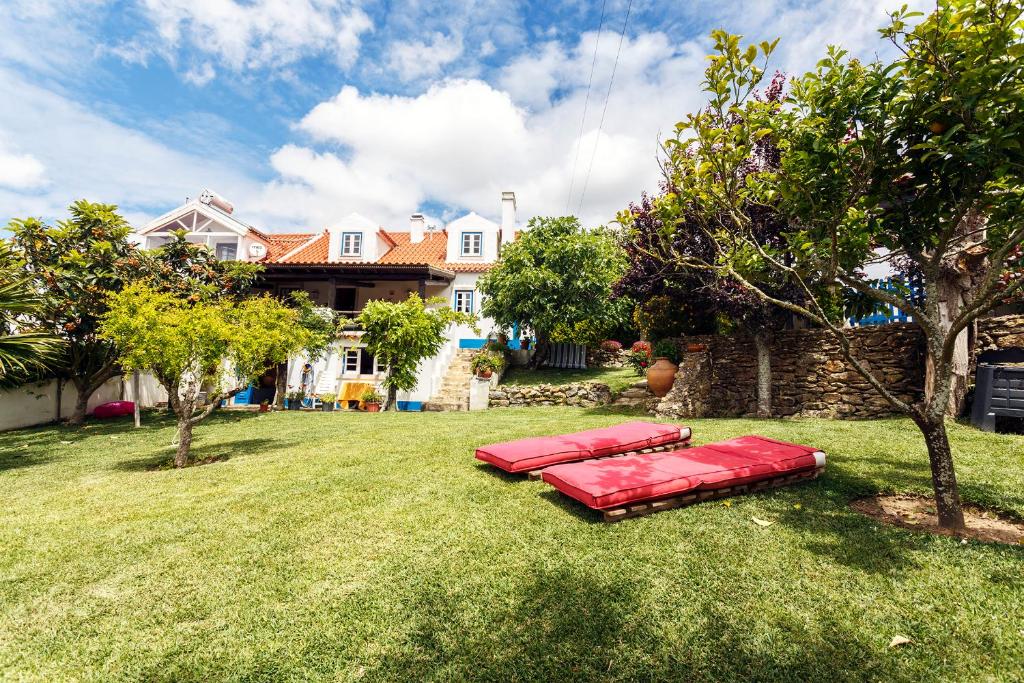 two red beds on the grass in front of a house at WHome Ericeira Private Villa in Mafra