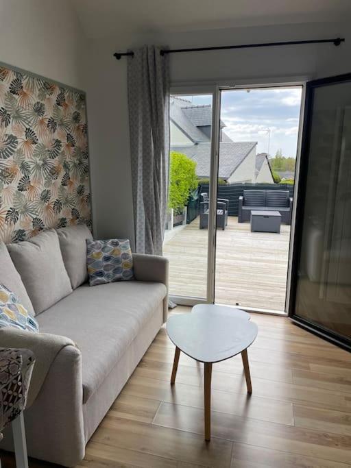 un salon avec un canapé et une table dans l'établissement Maison grande terrasse vue mer - Plage et GR34 à 400m, à Guidel