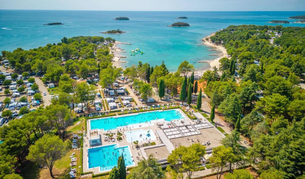 an aerial view of a resort with a pool and a beach at Eurocamp Mobile Homes at Campsite Valkanela in Funtana