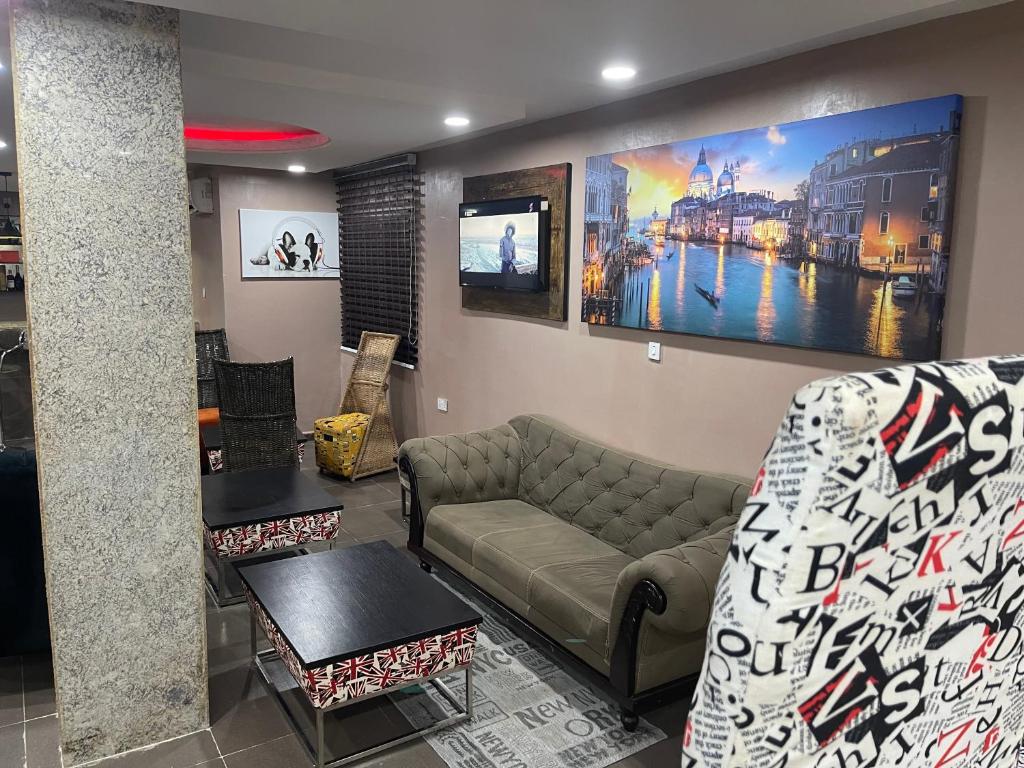 ein Wohnzimmer mit einem Sofa und einem TV in der Unterkunft C to C luxury hotel in Enugu