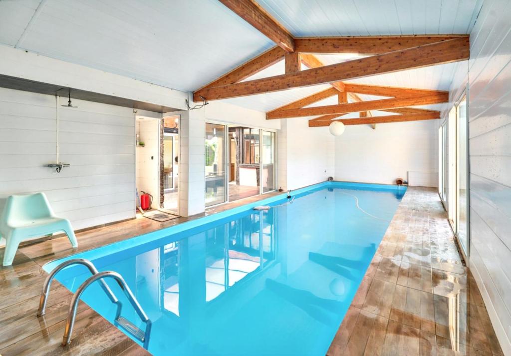 Villa de 3 chambres avec piscine interieure jacuzzi et jardin clos a Saint Antoine de Breuilh في Saint-Antoine-de-Breuilh: مسبح داخلي مع ماء أزرق في المنزل