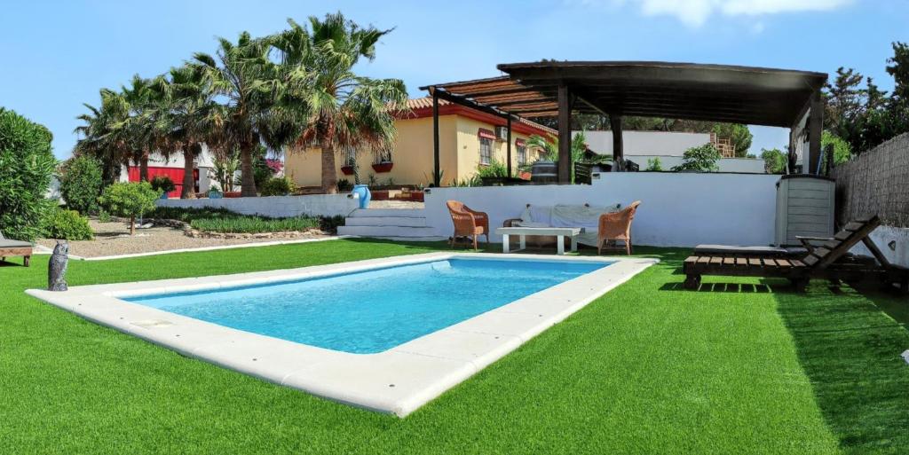 una piscina en un patio con mesa y sillas en 3 bedrooms villa with private pool enclosed garden and wifi at Chiclana de la Frontera 2 km away from the beach en Chiclana de la Frontera