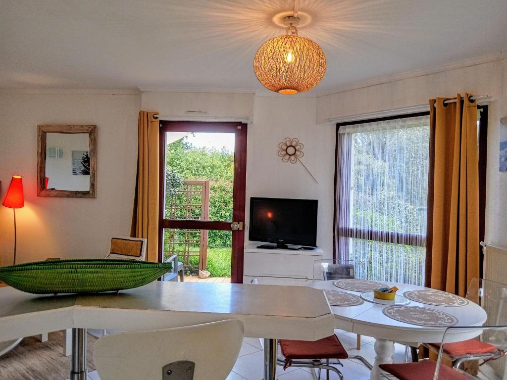 un salon avec une table, des chaises et une télévision dans l'établissement Le Seventys 3 pers Wifi Parking Vannes, à Vannes