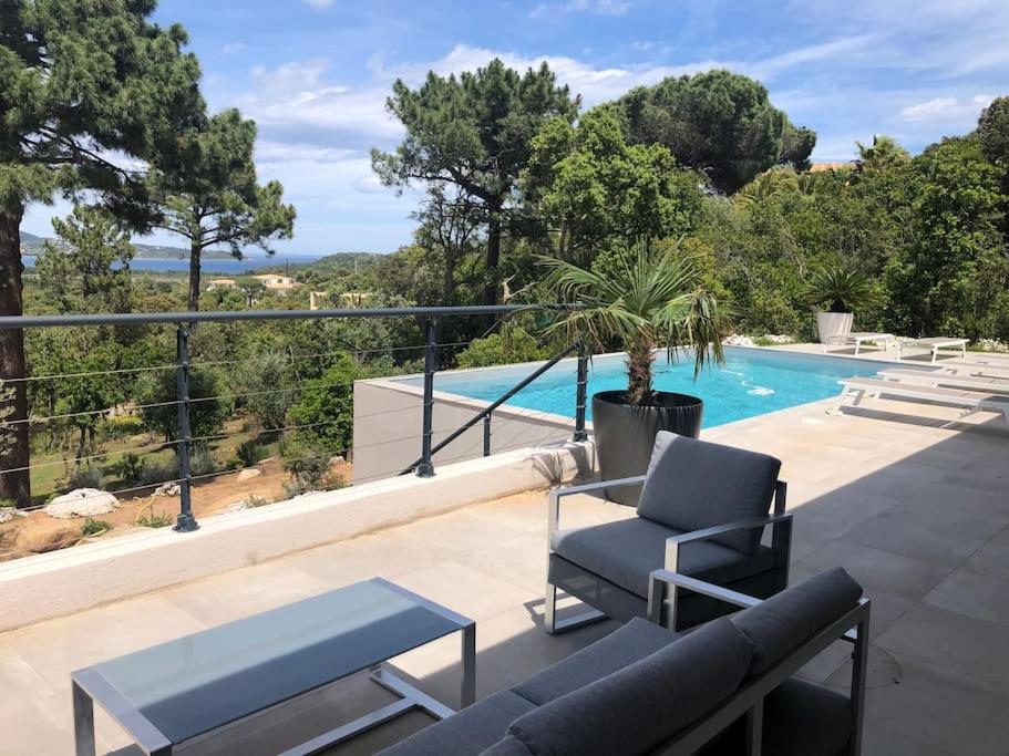 une terrasse avec un canapé et des chaises ainsi qu'une piscine dans l'établissement Villa privée-piscine-vue mer-pinarello-cirindinu, à Zonza