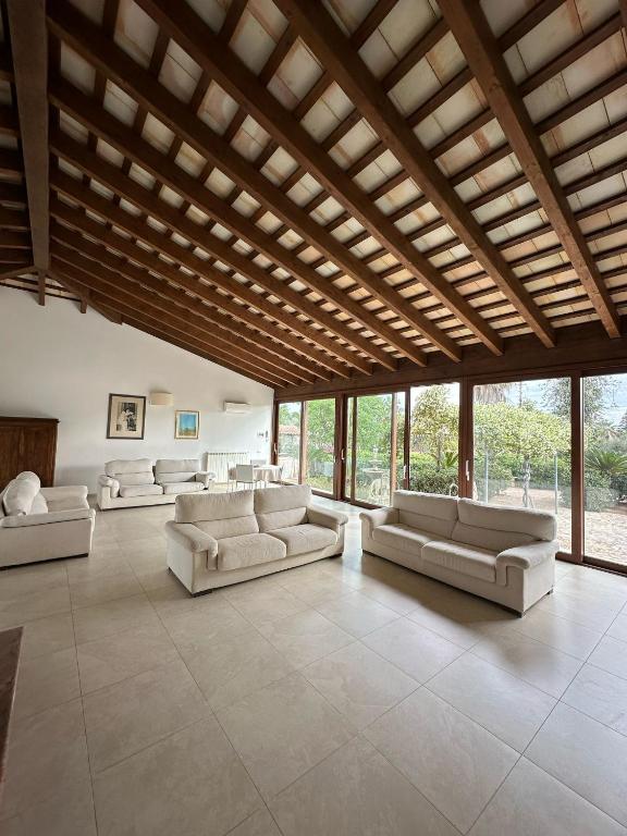 a large living room with white couches and windows at Villa delle Muse in Marsala