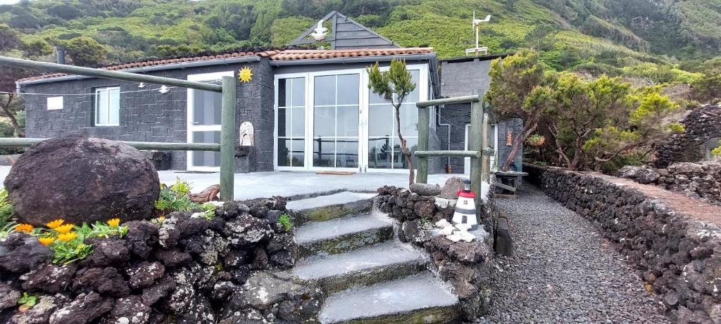 una casa con un conjunto de escaleras delante de ella en Casa do Caramba - The Dream House en São Roque do Pico