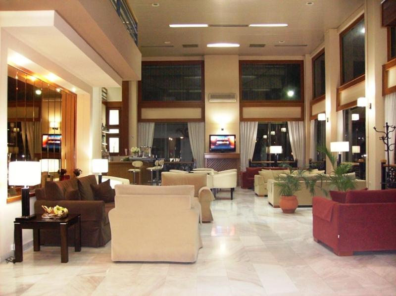 a lobby with couches and chairs in a building at Hotel Pantheon in Pyrgos