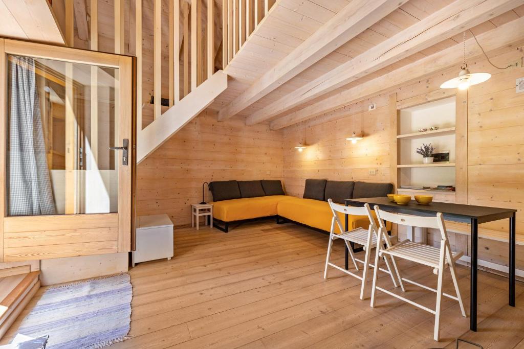 ein Wohnzimmer mit einem gelben Sofa und einem Tisch in der Unterkunft Wunderchalet in Daone