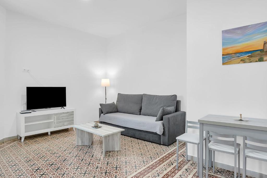 a living room with a couch and a tv at Apartamento Guzmán B in Barbate