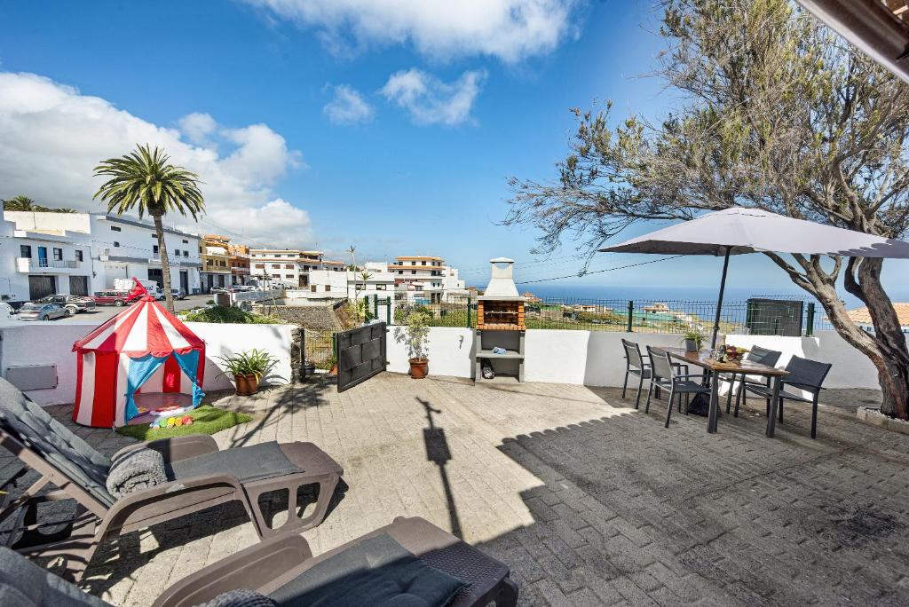 a patio with a table and an umbrella and the ocean at Casa Evarista in Icod de los Vinos