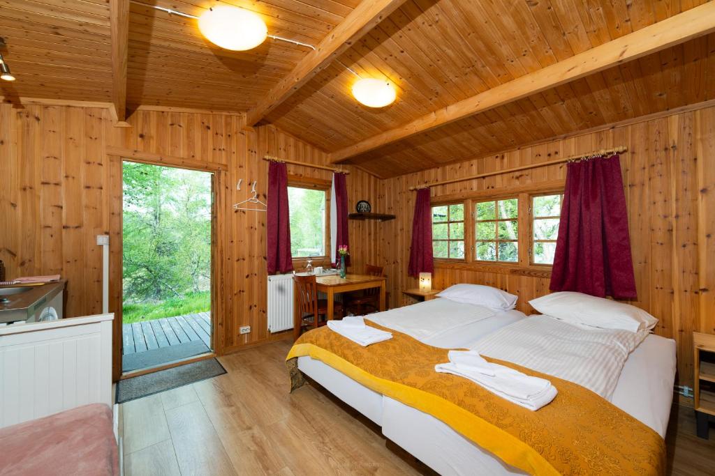 um quarto com uma cama em uma cabana de madeira em Hótel Eyvindará em Egilsstadir