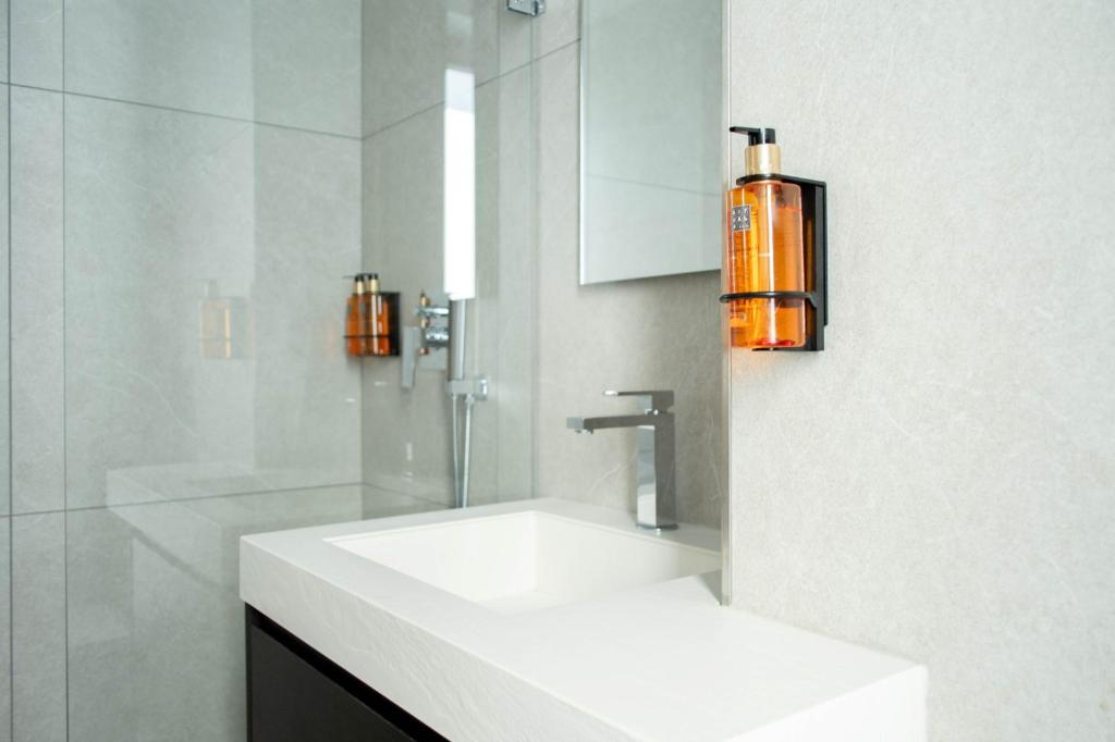 uma casa de banho branca com um lavatório e um espelho em Rumi Boutique Hotels&Spa Only adults em Ascea