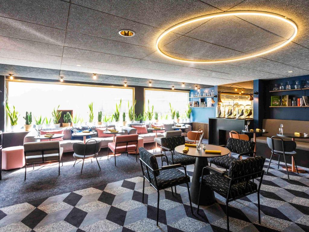 ein Restaurant mit Stühlen und Tischen sowie eine Bar in der Unterkunft Mercure Bordeaux Centre Ville in Bordeaux
