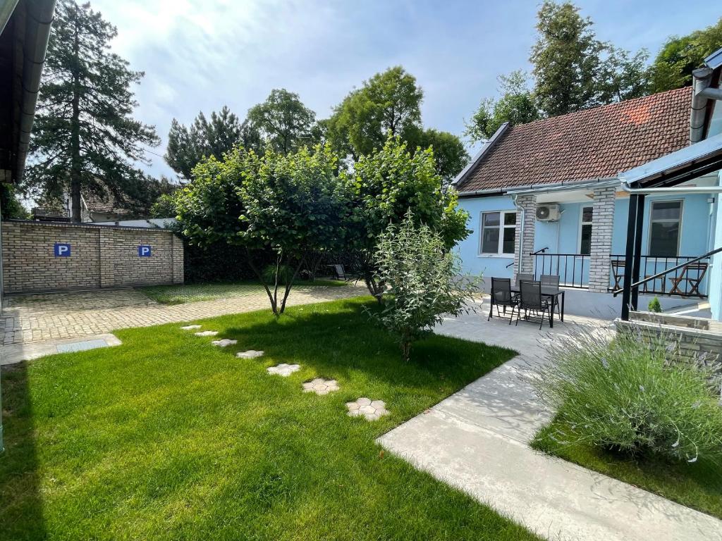 einen Garten mit einer Terrasse und einem Haus in der Unterkunft Apartmani 64 in Sombor