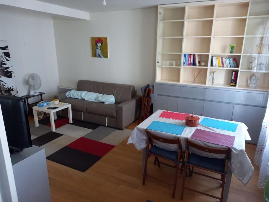 un salon avec une table et un canapé dans l'établissement Appartement 2 pièces, à Puteaux