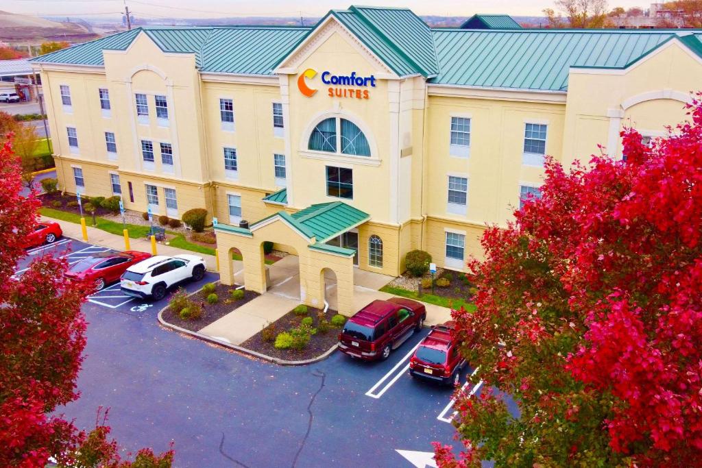 a view of a hotel with cars parked in a parking lot at Comfort Suites East Brunswick - South River in East Brunswick