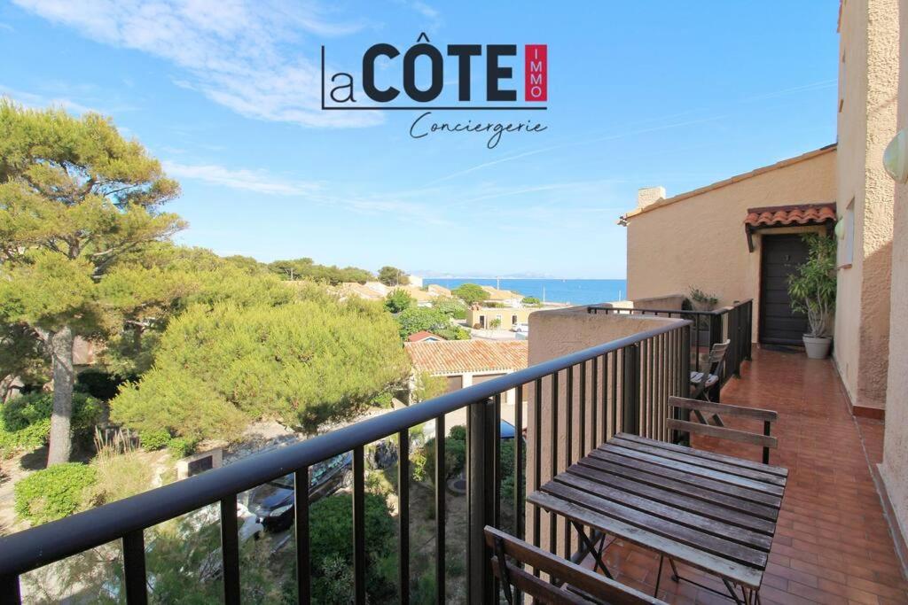 un balcon avec un banc en bois sur dans l'établissement Atlante, à Sausset-les-Pins