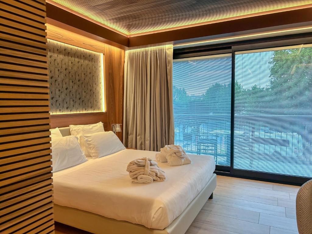 een slaapkamer met een bed met handdoeken erop bij Alevic Hotel Sirmione in Sirmione