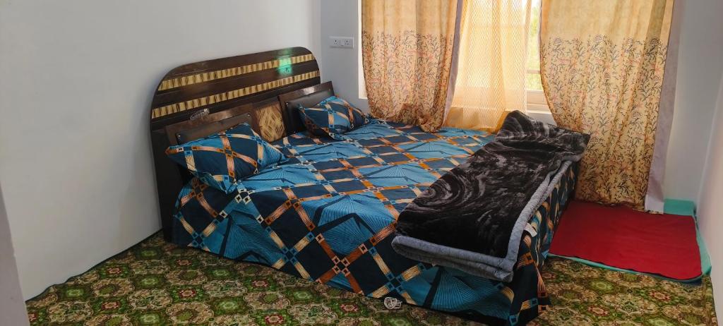 a bedroom with a bed with a blue comforter at magray guest house in Gulmarg