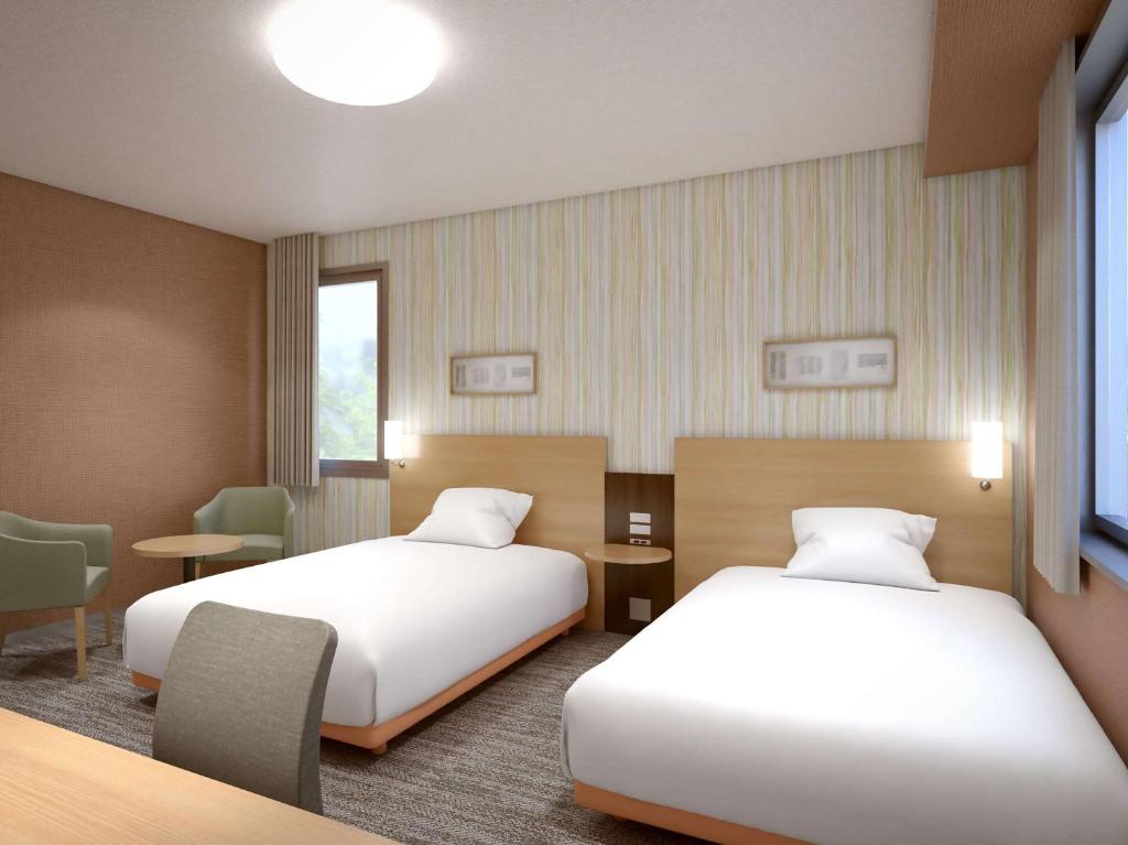 een hotelkamer met 2 bedden en een tafel bij Comfort Hotel Maebashi in Maebashi