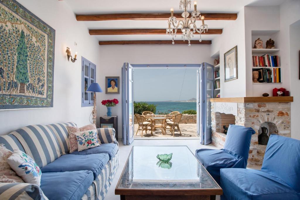a living room with a blue couch and a glass table at Orkos View House in Plaka