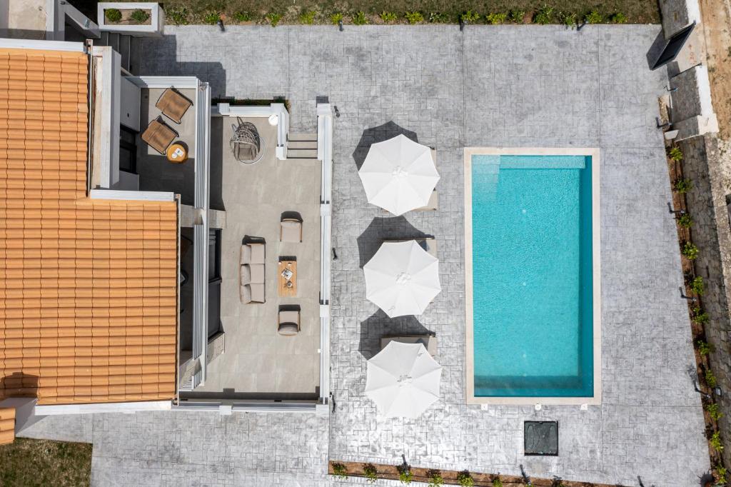 an overhead view of a swimming pool next to a building at Black Lotus Pool Villa, Afitos #FeelsLikeHome in Afitos