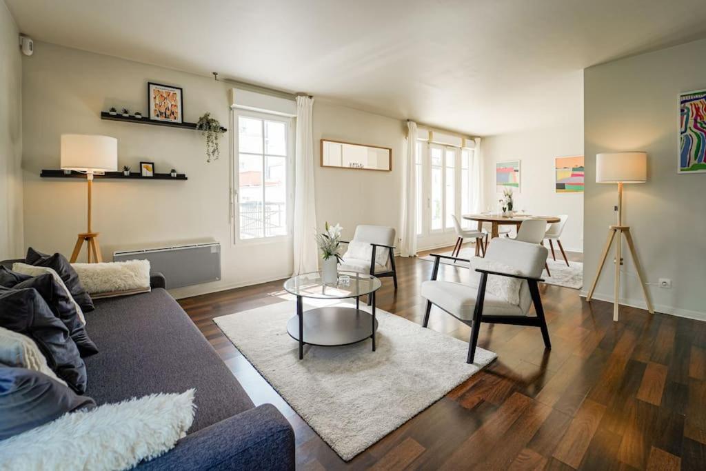 ein Wohnzimmer mit Sofa und Tisch in der Unterkunft Appartement avec Terrasse, Parking et WiFi, DisneyLand Paris in Chessy