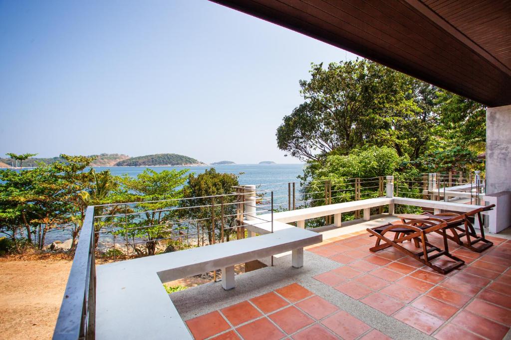 a porch with benches and a view of the water at Baan Krating Phuket Resort -SHA Plus in Nai Harn Beach