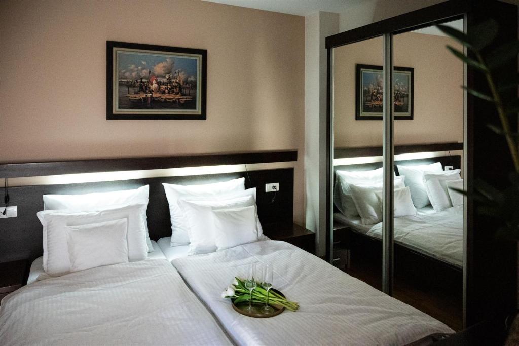 Habitación de hotel con cama y espejo en B&B Atrium, en Sremska Mitrovica