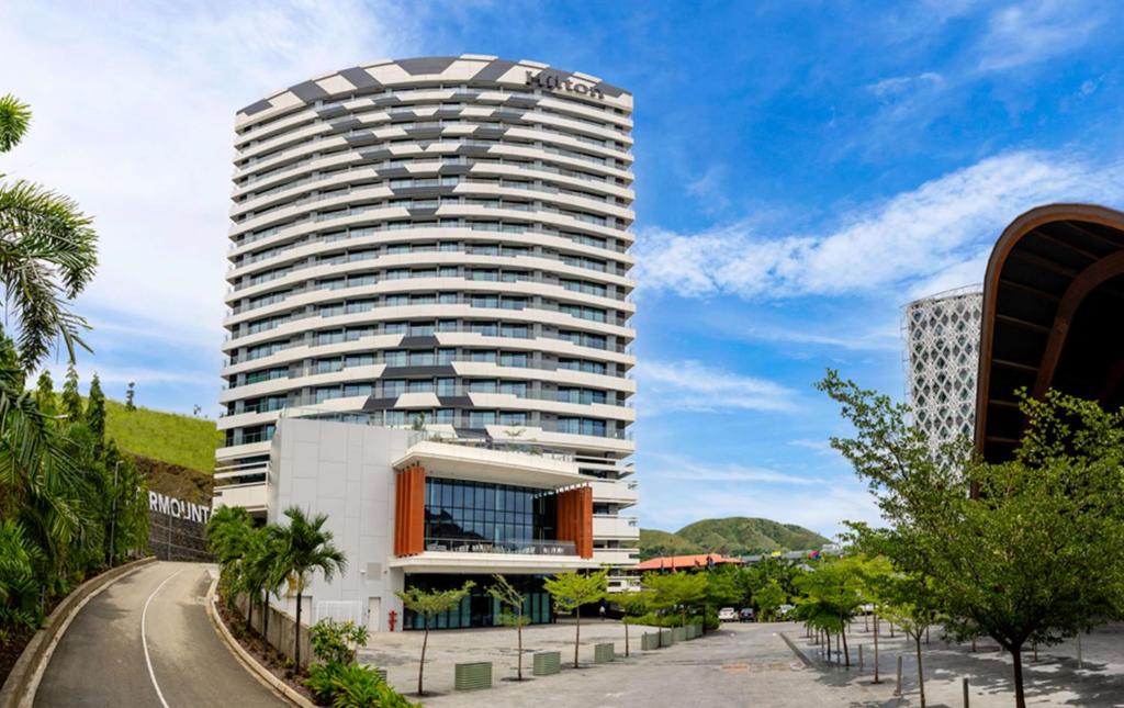 un edificio alto blanco con una parte superior redonda en Hilton Port Moresby Hotel & Residences en Port Moresby