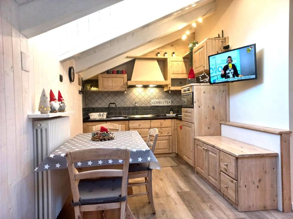 eine Küche mit einem Tisch und einem TV an der Wand in der Unterkunft Sotto le stelle nel cuore di Aosta in Aosta