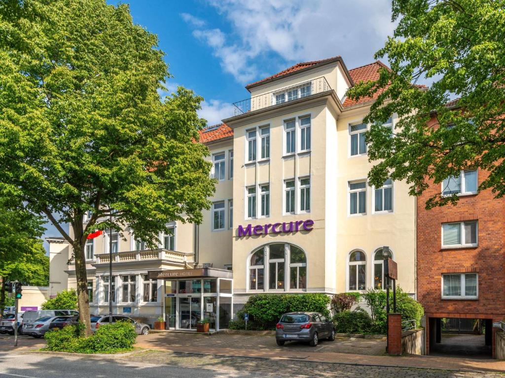 - un grand bâtiment blanc avec un panneau métallique dans l'établissement Mercure Hotel Luebeck City Center, à Lübeck