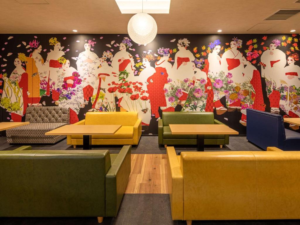 a restaurant with a large mural of dresses on the wall at Comfort Hotel ERA Kyoto Toji in Kyoto