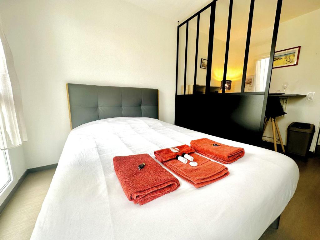 un lit avec deux serviettes dessus dans l'établissement Studio 13 min plage - Parking - Ménage & Linge inclus, à La Rochelle