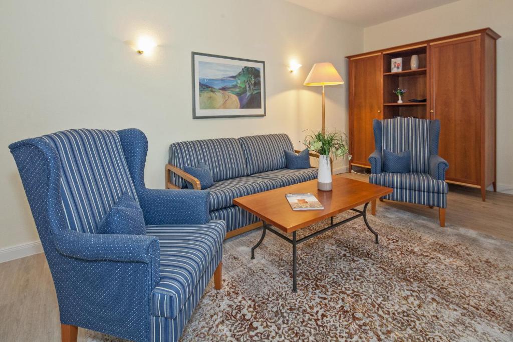 uma sala de estar com duas cadeiras azuis e uma mesa de centro em Strand-Park Strand-Park V21 em Heringsdorf