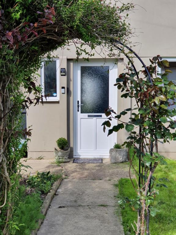 a white door of a house with a plant at Rose House, with garden, ideal for couples and families with easy parking in Kent