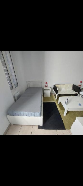 une chambre blanche avec un lit et une table dans l'établissement Studio - 2 personnes, à Marseille