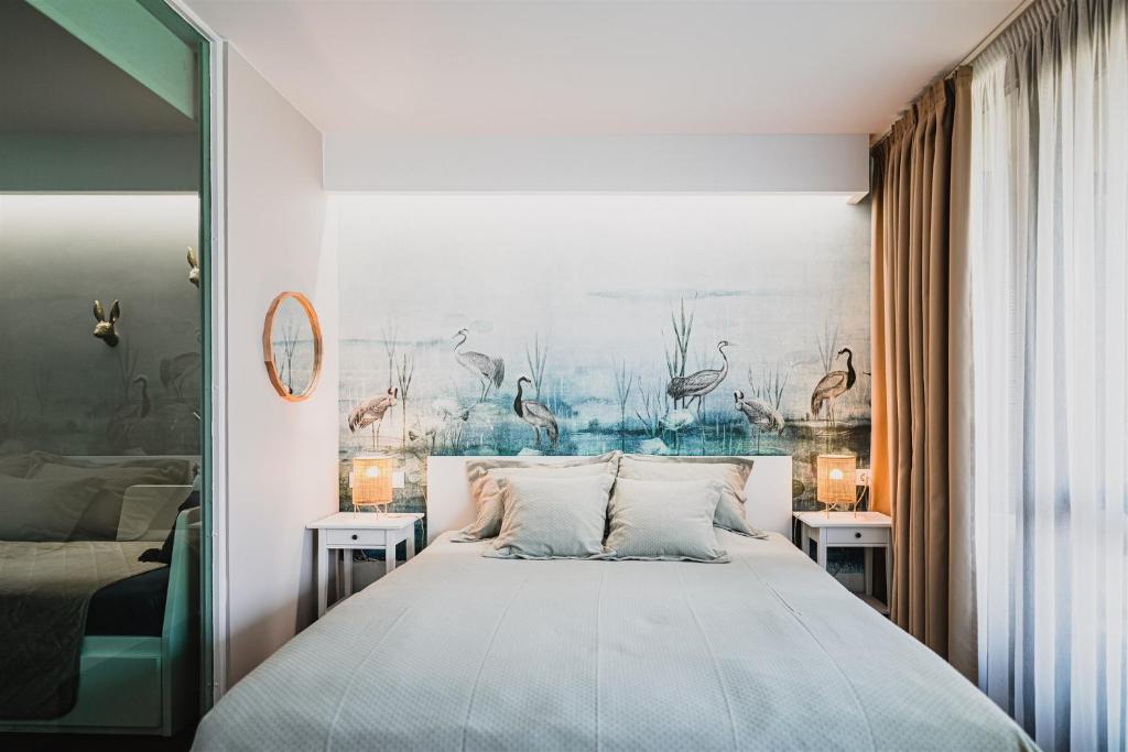 1 dormitorio con 1 cama y una pintura en la pared en Butique Apartman Grand en Balatonlelle