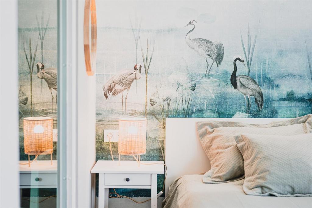 um quarto com um mural de pássaros na parede em Butique Apartman Grand em Balatonlelle