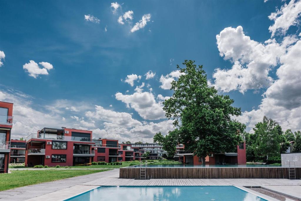 dziedziniec z drzewem i budynek w obiekcie Butique Apartman Grand w mieście Balatonlelle