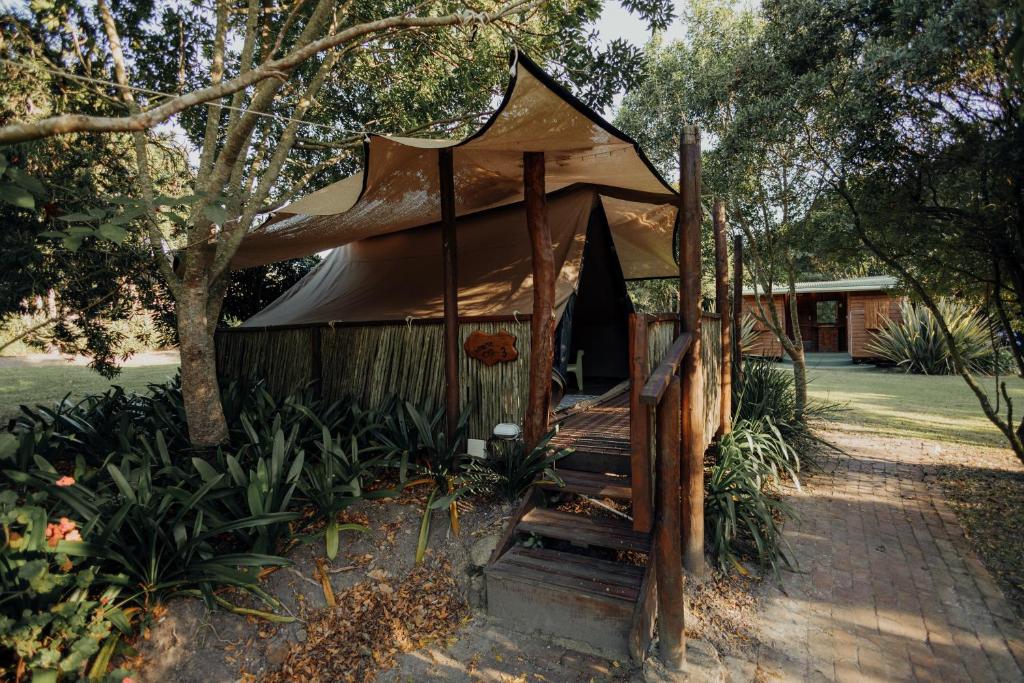 a gazebo with a tent in a yard at Firefly Falls in Plettenberg Bay