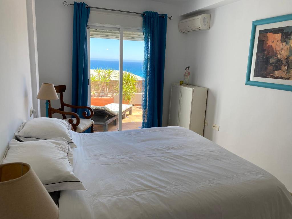 a bedroom with a bed and a view of the ocean at Apto Calle España in Mojácar