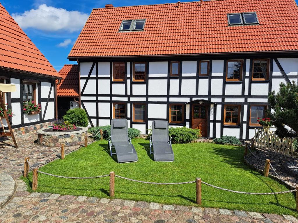 a house with two beds in the grass in front of it at Szachulcowa Zagroda in Ustka