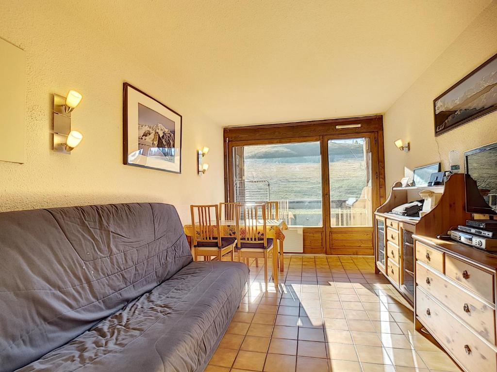 un salon avec un canapé et une cuisine avec une table dans l'établissement Chavanne - appartement - 4pers- Ski-inout, aux Gets