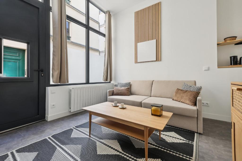 un salon avec un canapé et une table basse dans l'établissement Studio de Charme au Cœur de Paris!, à Paris