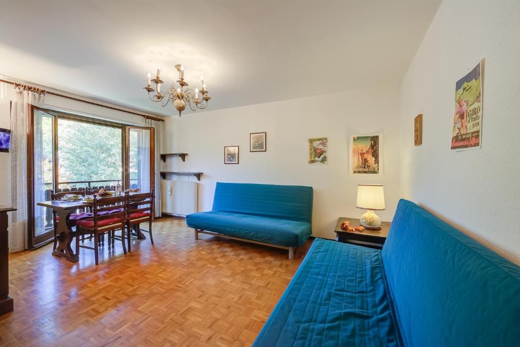 ein Wohnzimmer mit einem blauen Sofa und einem Tisch in der Unterkunft Il Nido di Elda few steps from skiing - Happy Rentals in Bardonecchia
