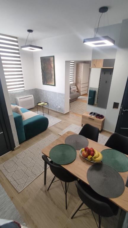 een woonkamer met een tafel met een fruitschaal erop bij Apartmani Park in Novi Pazar