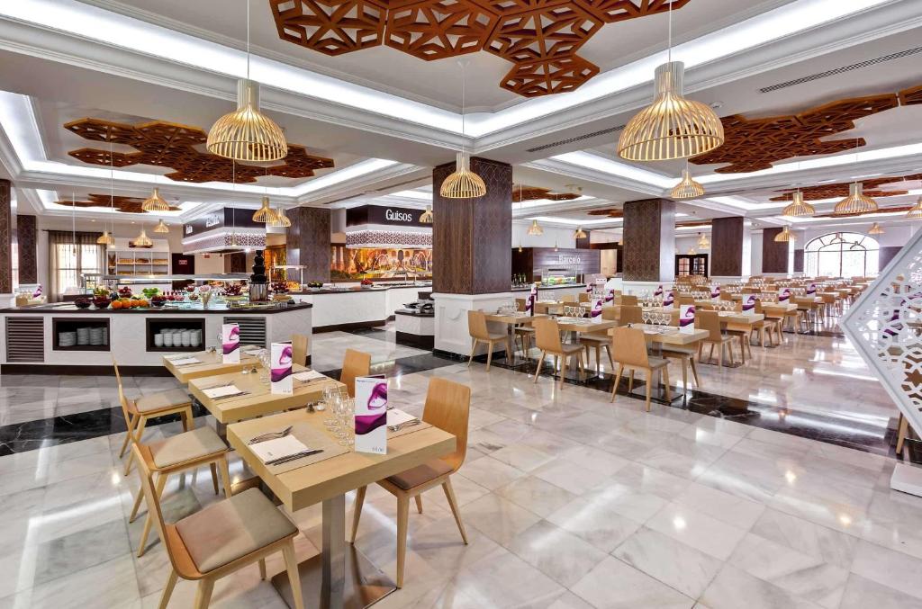 a restaurant with tables and chairs and a bar at Barceló Isla Canela in Isla Canela