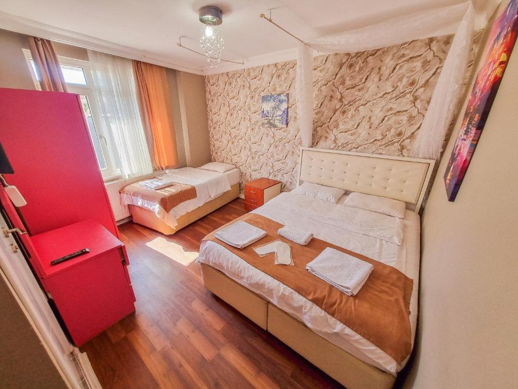 a bedroom with two beds and a red cabinet at White Palace Büyükada in Adalar