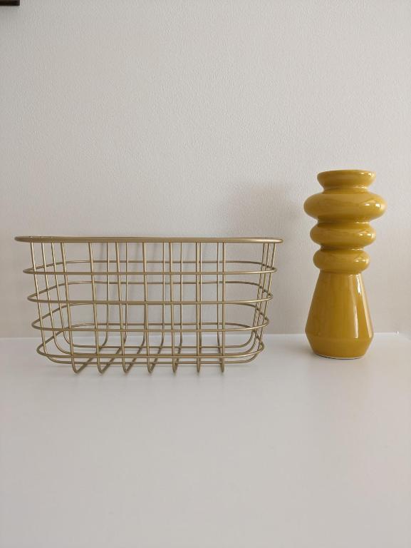 a metal wire basket next to a yellow vase at La Mimosa in Puentedeume